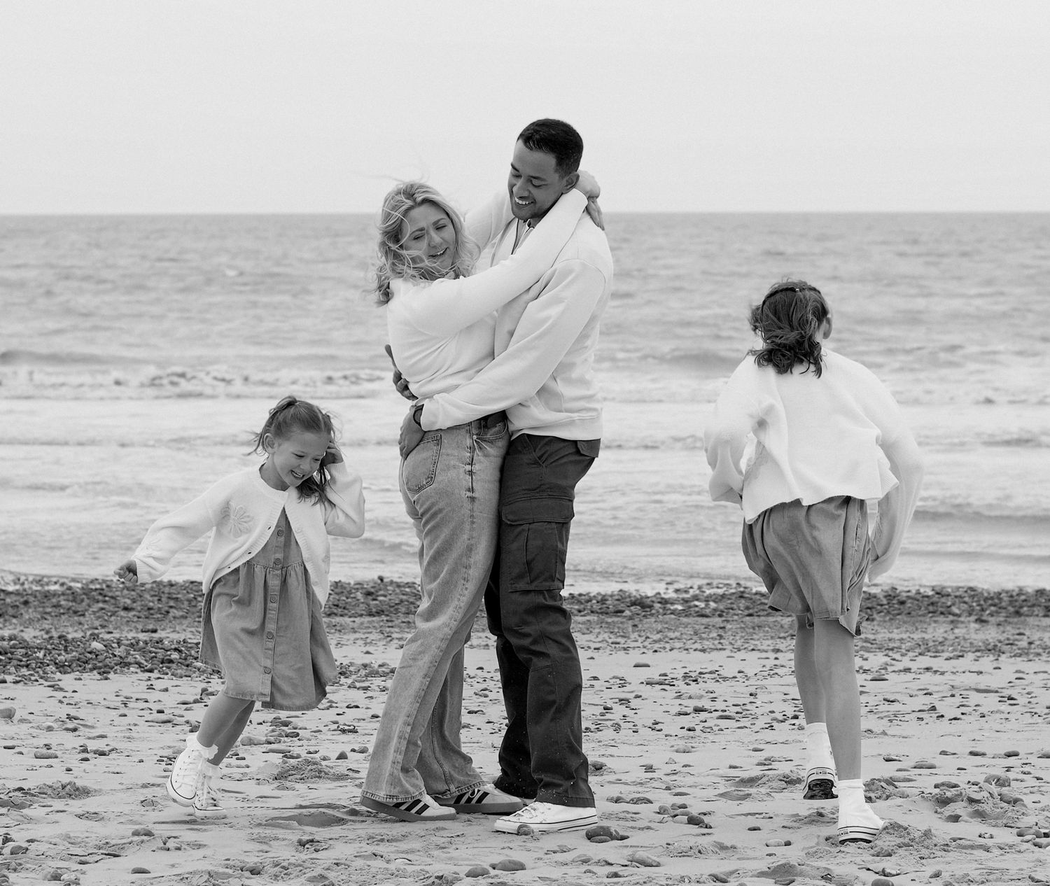 Black and white photo of a family playing on the beach