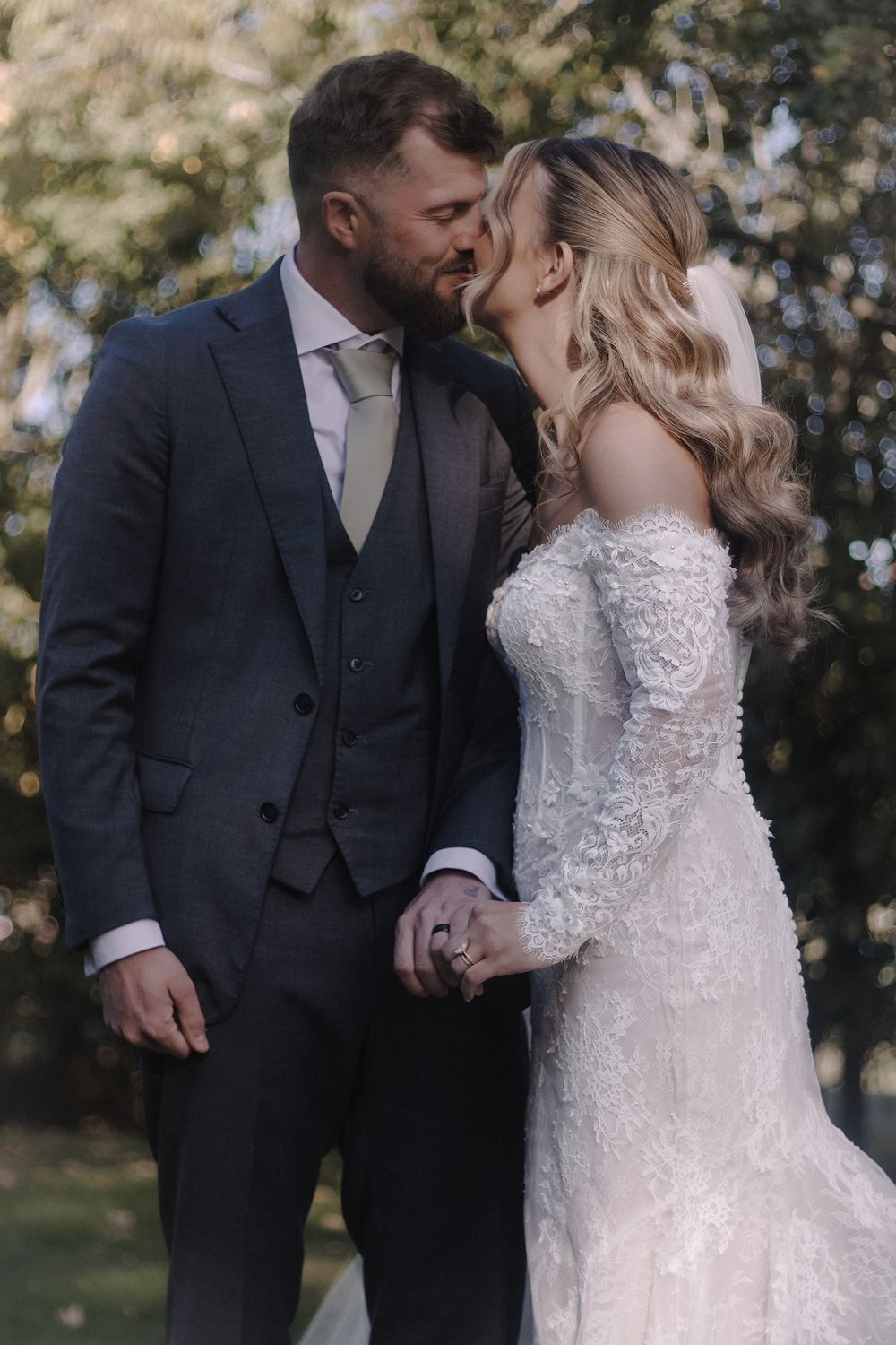 Bride and groom kissing in a garden